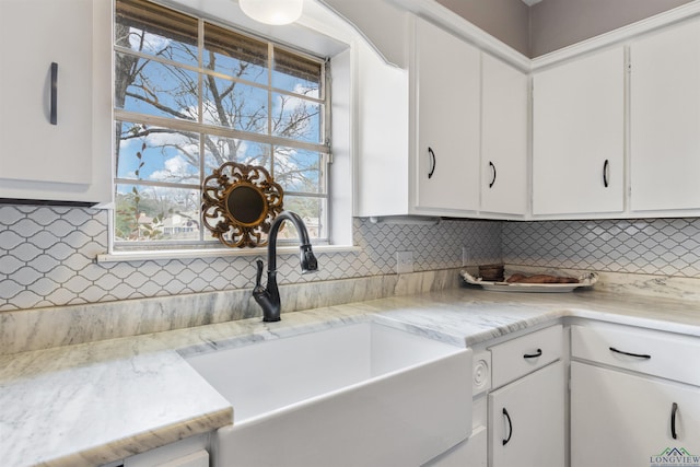 kitchen featuring backsplash, sink, and white cabinets