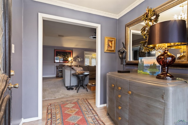 entrance foyer with ornamental molding and light hardwood / wood-style flooring