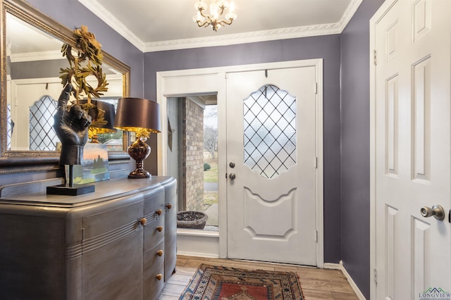 foyer entrance with crown molding, a chandelier, and light hardwood / wood-style floors