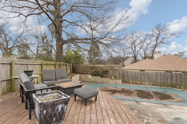 deck with a covered pool and an outdoor living space with a fire pit