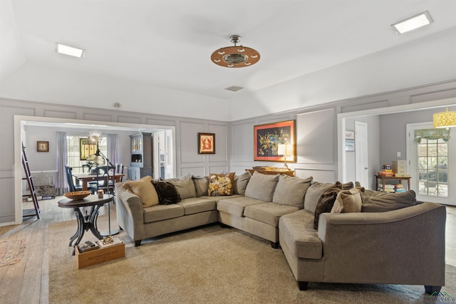 living room featuring lofted ceiling and hardwood / wood-style floors