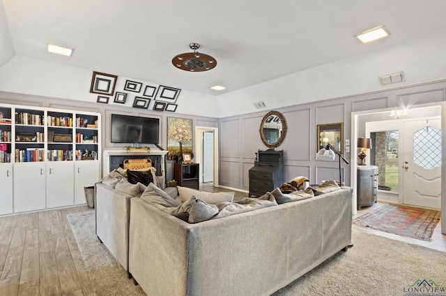 living room with lofted ceiling and light hardwood / wood-style flooring