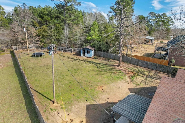 view of yard with a storage shed, a playground, and a trampoline