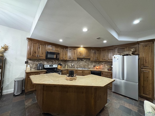 kitchen featuring a center island, a raised ceiling, crown molding, decorative backsplash, and black appliances