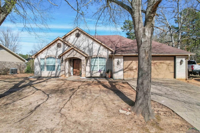 view of front of property with a garage and central AC