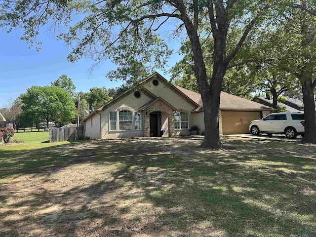 bungalow with a front yard, fence, and a garage