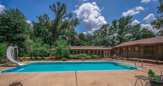 view of swimming pool with a patio area and a water slide