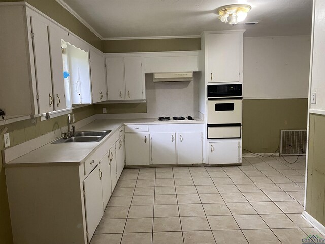 kitchen with a sink, light tile patterned flooring, a warming drawer, white appliances, and light countertops