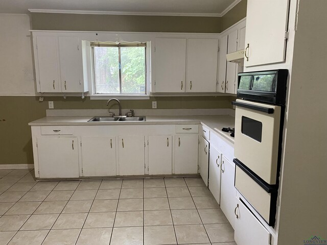 kitchen featuring oven, light countertops, a sink, and light tile patterned floors