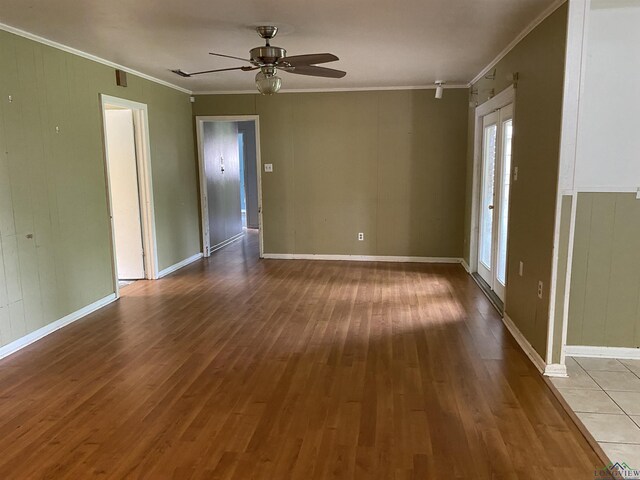 unfurnished room featuring a ceiling fan, ornamental molding, and wood finished floors