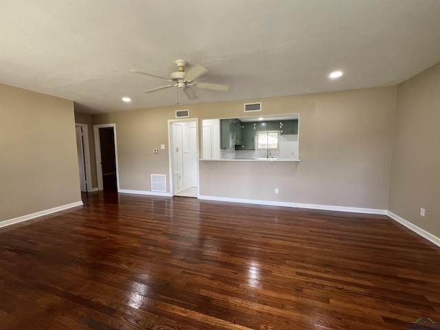 unfurnished living room featuring ceiling fan, sink, and dark hardwood / wood-style floors