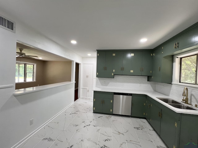 kitchen with dishwasher, backsplash, green cabinets, and sink