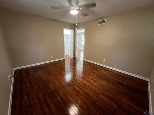 spare room with ceiling fan and dark wood-type flooring