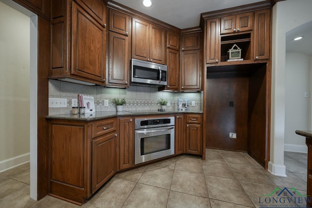 521 Hideaway Ln, Central, Hideaway, TX 75771 - kitchen featuring appliances with stainless steel finishes, light tile patterned flooring, and backsplash
