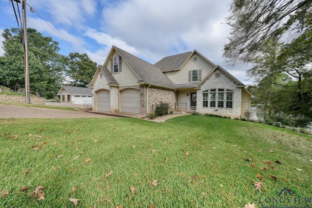 view of front of home with driveway, brick siding, a garage, and a front yard