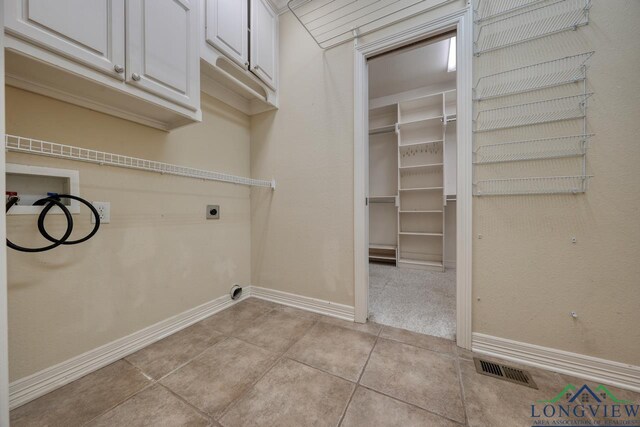 521 Hideaway Ln, Central, Hideaway, TX 75771 - laundry room with light tile patterned floors, hookup for a washing machine, hookup for an electric dryer, baseboards, and cabinet space