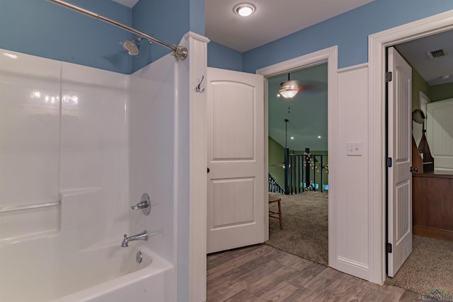 bathroom with hardwood / wood-style flooring and shower / tub combination