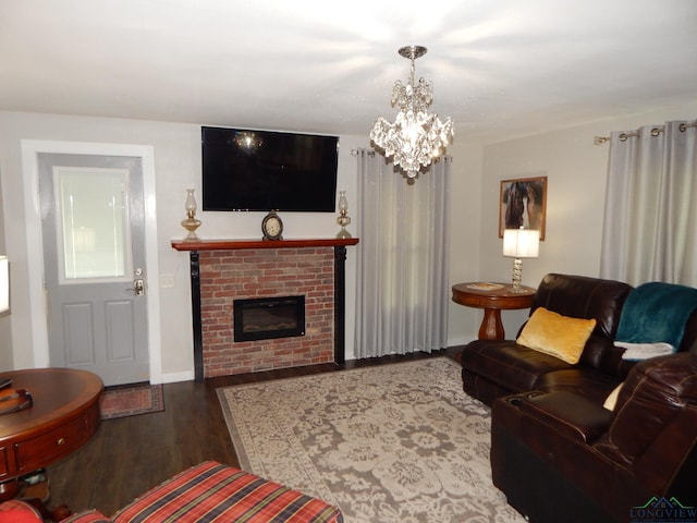 living room featuring dark hardwood / wood-style flooring, a fireplace, and a chandelier