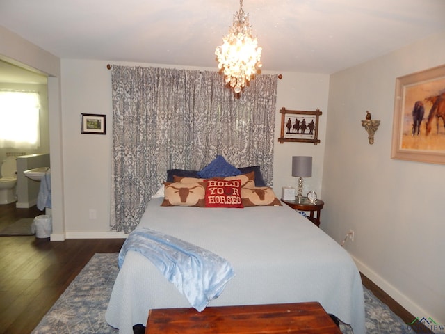 bedroom with a notable chandelier, ensuite bathroom, and dark hardwood / wood-style flooring