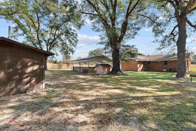 view of yard with central AC unit and an outdoor structure