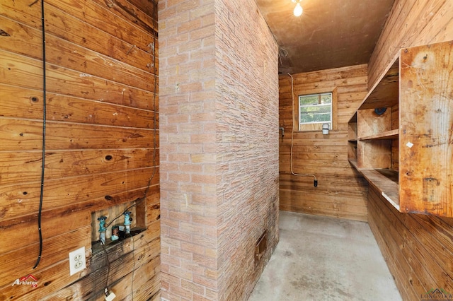 interior space with concrete flooring and wooden walls