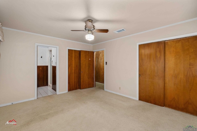 unfurnished bedroom with ceiling fan, light colored carpet, crown molding, and connected bathroom