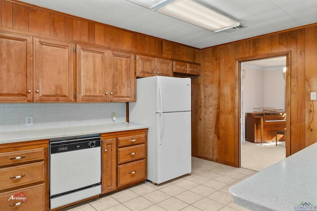 kitchen with light tile patterned floors, white appliances, tasteful backsplash, and crown molding