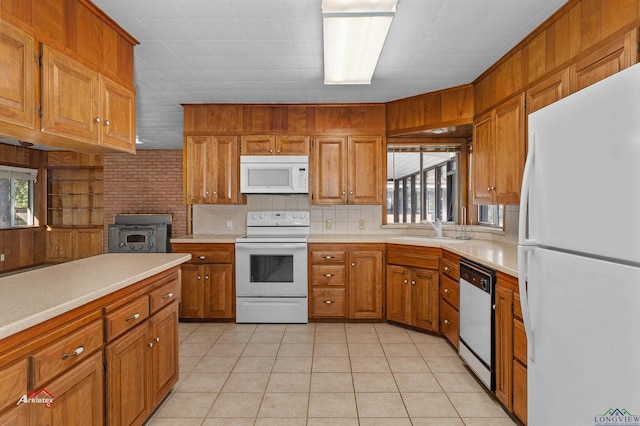 kitchen with light tile patterned floors, white appliances, tasteful backsplash, and sink