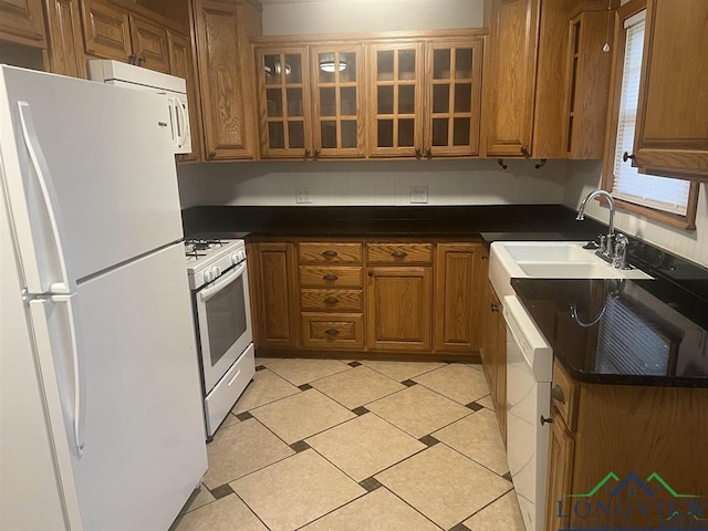 kitchen featuring white appliances, light tile patterned flooring, plenty of natural light, and sink