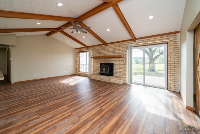 unfurnished living room with a wood stove, ceiling fan, lofted ceiling with beams, and hardwood / wood-style flooring