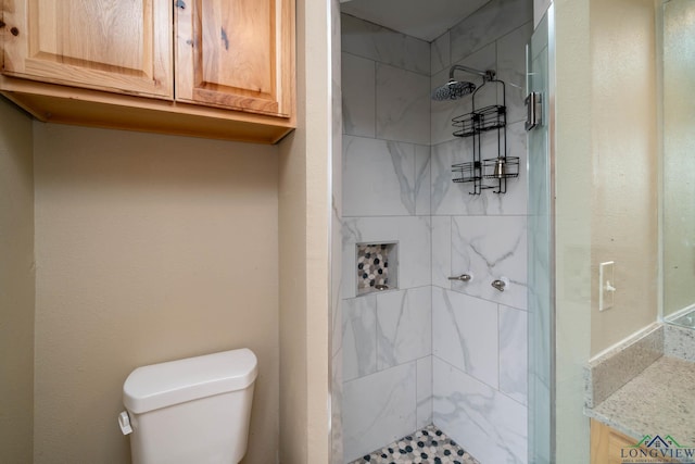 bathroom with toilet and a tile shower