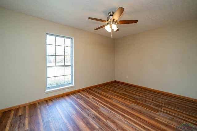 empty room with ceiling fan and dark wood-type flooring