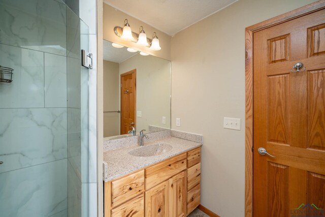 bathroom featuring a tile shower and vanity