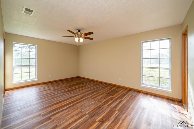 empty room featuring a textured ceiling, ceiling fan, and dark wood-type flooring