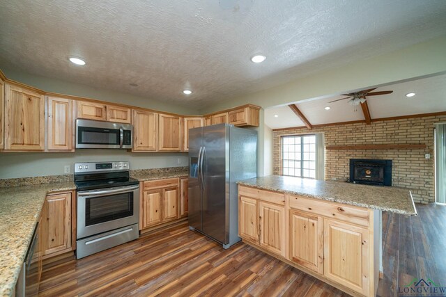 kitchen featuring ceiling fan, dark hardwood / wood-style floors, a textured ceiling, appliances with stainless steel finishes, and kitchen peninsula