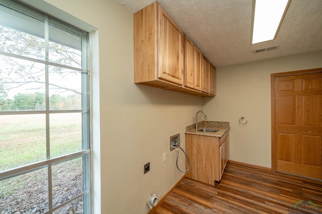 laundry area featuring sink, cabinets, hookup for an electric dryer, dark hardwood / wood-style floors, and hookup for a washing machine