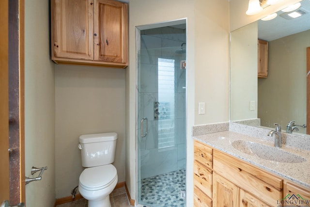 bathroom with tile patterned floors, vanity, toilet, and a shower with door