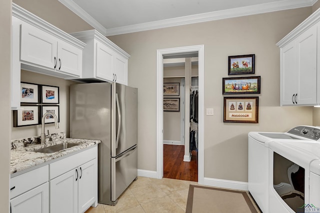 kitchen featuring white cabinetry, sink, and stainless steel refrigerator