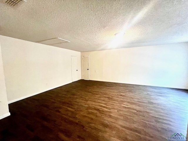 unfurnished room featuring a textured ceiling and dark hardwood / wood-style floors