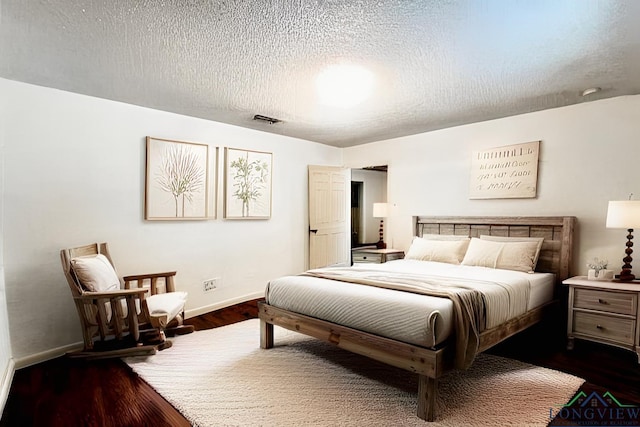 bedroom featuring dark wood-type flooring and a textured ceiling