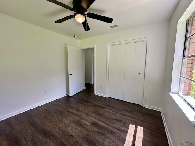 1505 E Birdsong, Longview, TX 75602 - unfurnished bedroom with dark wood-type flooring, baseboards, a closet, and ceiling fan