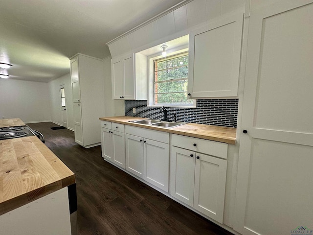 1505 E Birdsong, Longview, TX 75602 - kitchen with butcher block countertops, a sink, decorative backsplash, dark wood-type flooring, and white cabinets