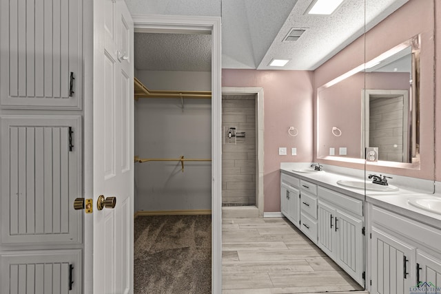 5 Amy Scott Ct, Longview, TX 75605 - full bath featuring double vanity, a walk in closet, a textured ceiling, and wood finished floors