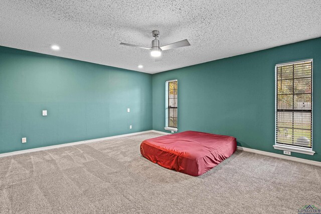 5 Amy Scott Ct, Longview, TX 75605 - bedroom featuring carpet flooring, multiple windows, a textured ceiling, a ceiling fan, and recessed lighting