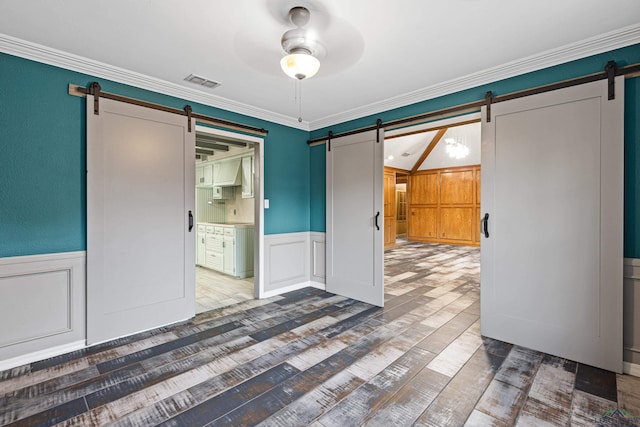 5 Amy Scott Ct, Longview, TX 75605 - unfurnished bedroom with a barn door, a decorative wall, wood finished floors, a wainscoted wall, and ornamental molding
