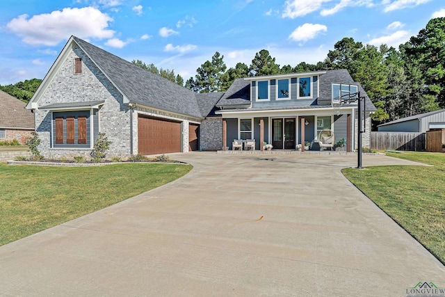 view of front of home featuring a garage, covered porch, and a front lawn