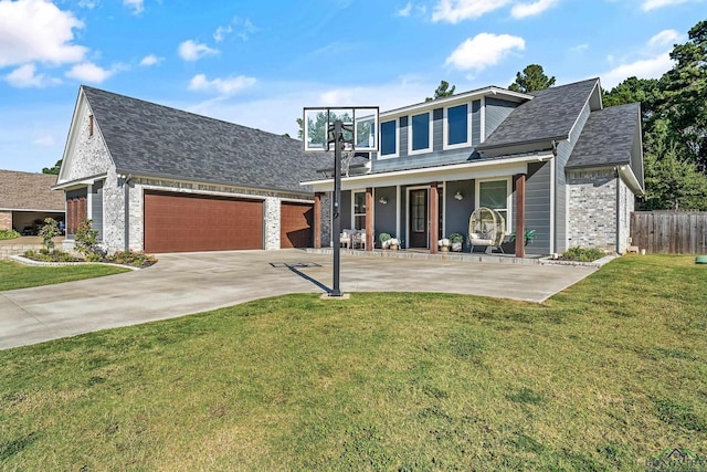 view of front of property featuring covered porch, a garage, and a front lawn