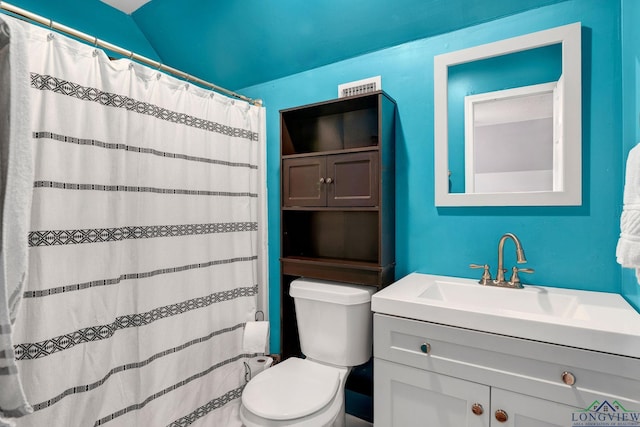 bathroom with curtained shower, vanity, vaulted ceiling, and toilet