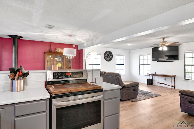 kitchen with electric range, decorative light fixtures, gray cabinets, and a textured ceiling