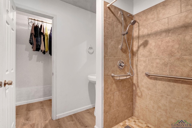 bathroom featuring wood-type flooring and tiled shower